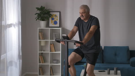 Un-Anciano-Atlético-Está-Entrenando-En-Bicicleta-Estática-En-Casa,-Retrato,-Manteniendo-La-Condición-Física,-Deporte-Y-Actividad-Para-La-Salud.